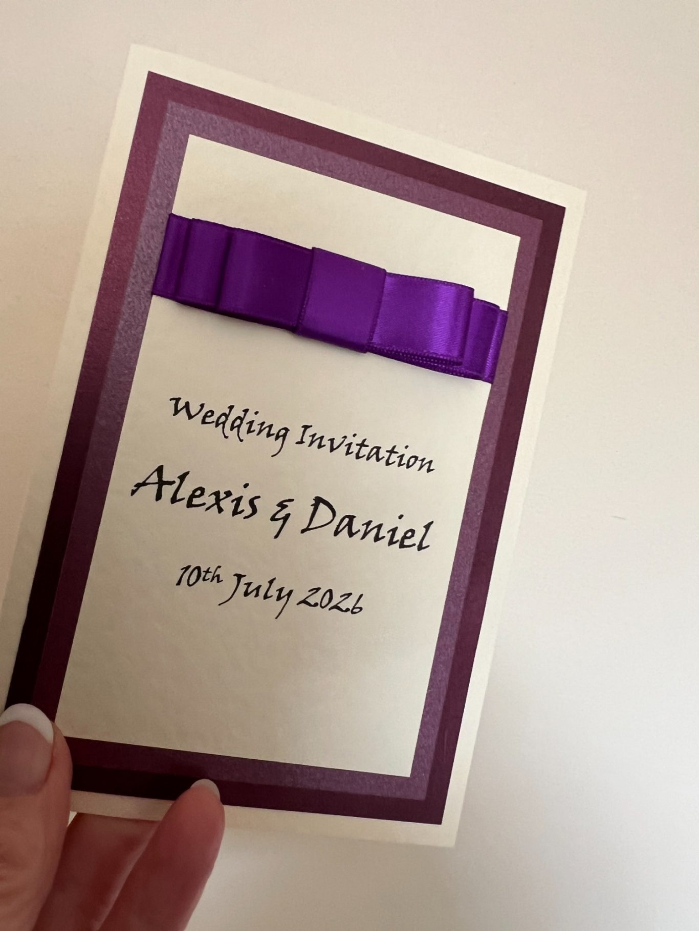Invitation on ivory hammered with purple trims