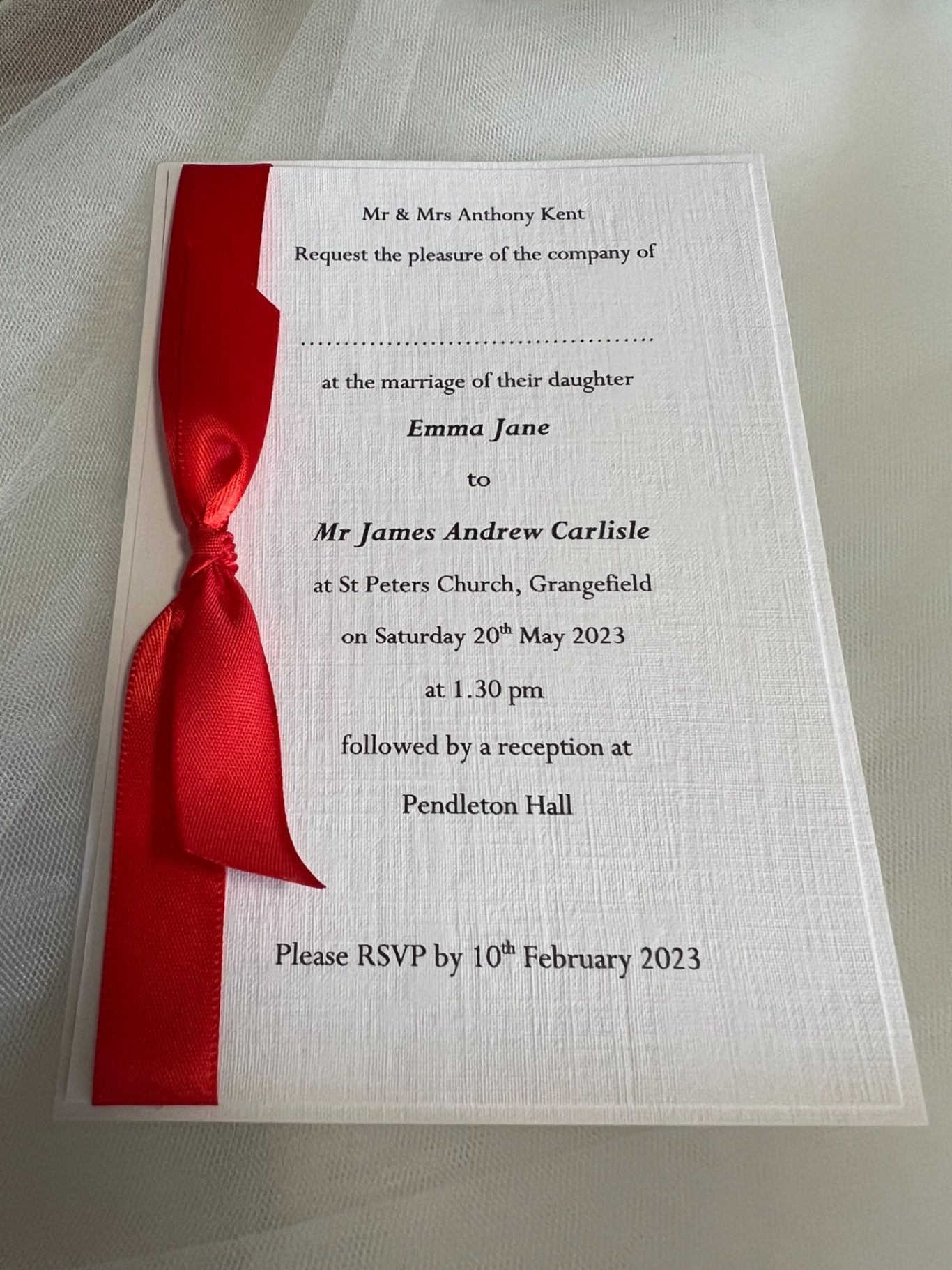 Invitation with red satin ribbon and white linen card